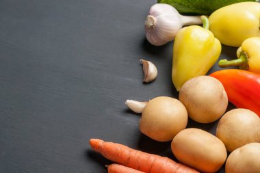 Farklı taze bütün olgun sebze seti koyu beton masa üzerinde yatıyor. Metin için alan kopyalama