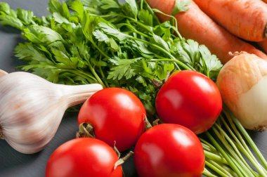 Farklı taze bütün olgun sebze seti koyu beton masa üzerinde yatıyor