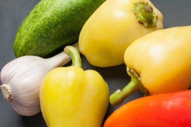 Farklı taze bütün olgun sebze seti koyu beton masa üzerinde yatıyor