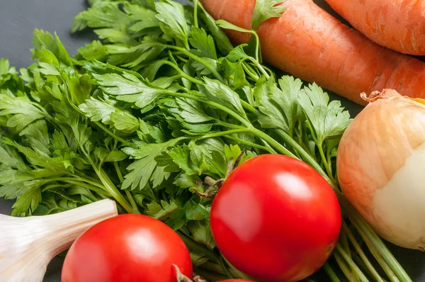 Farklı taze bütün olgun sebze seti koyu beton masa üzerinde yatıyor