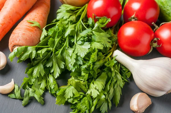 Farklı taze bütün olgun sebze seti koyu beton masa üzerinde yatıyor