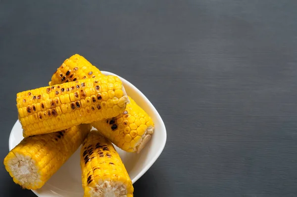 Whole White Ceramic Plate Full Fried Corn Cobs Lies Dark — Stock Photo, Image