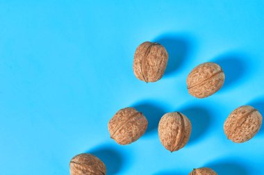 Olgun cevizleri mavi arka plana serpiştirdim. Uzayı kopyala Üst görünüm