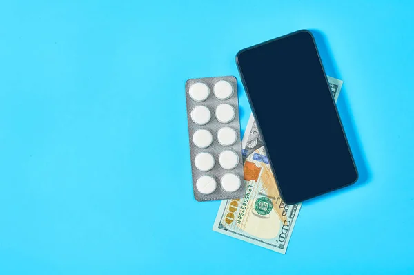 Smartphone Cerca Pastillas Billete Cien Dólares Sobre Fondo Azul Salud —  Fotos de Stock