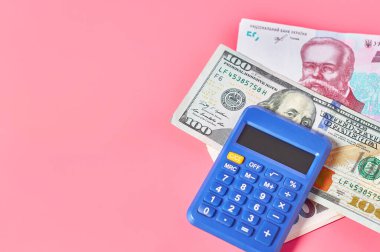Pembe arka planda yığınla para ve hesap makinesi. Ödeme kavramı