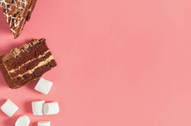Farklı tatlıların yanında çikolatalı kek parçaları pembe masanın üzerinde yatıyor. Uzayı kopyala Üst görünüm