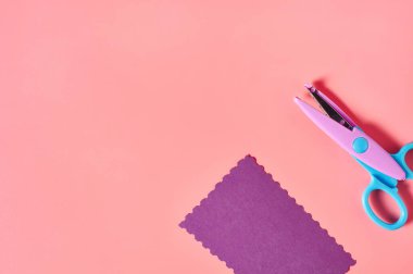 Dekoratif kıvrımlı kağıt kesme makası. Pembe zemin üzerinde dalga sınırı olan el sanatları için. El yapımı, boş zaman ve anaokulu eğitimi kavramı