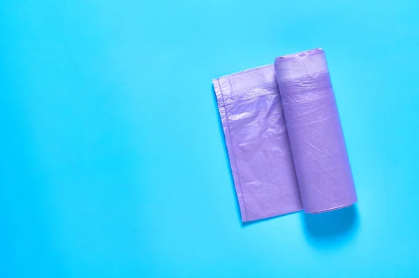 Een Paarse Wegwerp Plastic Vuilniszak Blauwe Achtergrond Begrepen Ruimte Bovenaanzicht — Stockfoto