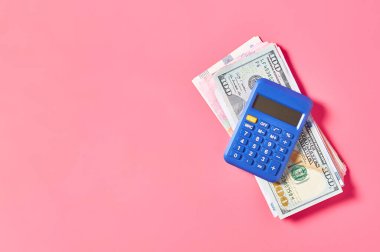 Pembe arka planda yığınla banknot ve hesap makinesi. Ödeme kavramı