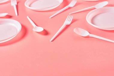 Pembe arka plana saçılmış tek kullanımlık plastik kaplar. Çevreyi, ekolojiyi, piknik, parti ve diğer etkinlikleri kurtarma kavramı. Boşluğu kopyala