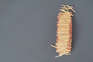 Bir sürü yeni kibrit çöpü. Mutfaktaki koyu beton masada kızıl saçlı. Mesaj için yer var. Üst görünüm