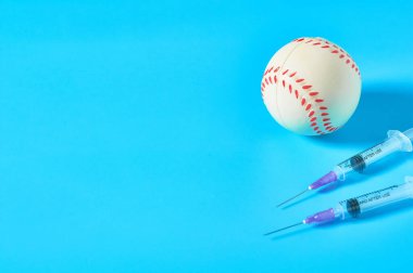 Mavi arka planda şırınganın yanında beyzbol topu var. Profesyonel sporda doping kavramı. Rehabilitasyon, yarışmadan sonra tedavi. Turnuvada kullanılan yasadışı ilaçlar