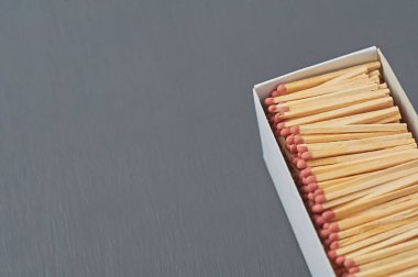 Mutfaktaki koyu beton masada kırmızı sülfür bulunan bir sürü kibrit çöpünden oluşan büyük bir karton kutu. Metin için boşluk