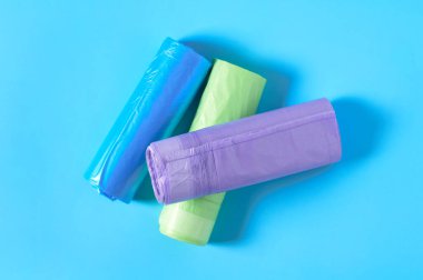 Mavi arka planda bir yığın tek kullanımlık plastik çöp torbası. Üst Manzara. Yakın plan.