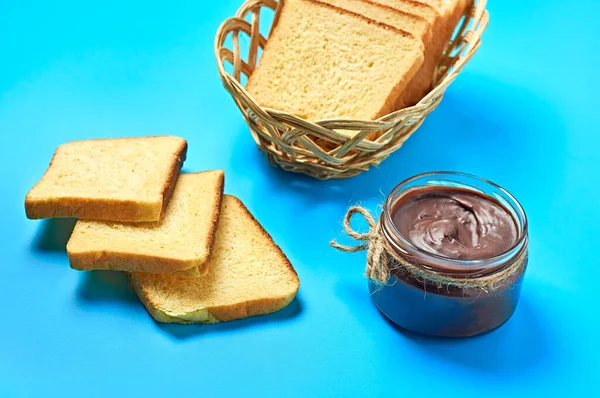 Tek cam şeffaf kavanoz, halatla dolu erimiş çikolata ya da ahşap sepetin yanında vanilyalı ekmek parçaları mutfak masasında duruyor. Besleyici kahvaltı ya da öğle yemeği kavramı