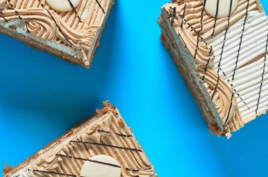 Partide mavi masanın üzerinde üç dikdörtgen pasta var. Kutlama konsepti. Üst Manzara. Yakın plan.