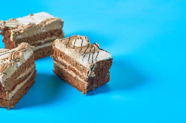 Partide mavi masanın üzerinde üç dikdörtgen pasta var. Kutlama konsepti. Metin için boşluk