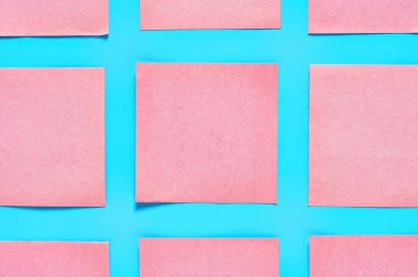 Mavi arka planda pembe kare boş kağıt etiketleri. Uzayı kopyala Üst görünüm