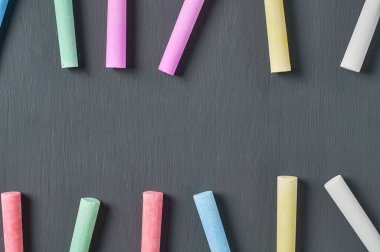 Siyah karatahtaya bir sürü renkli tebeşir parçaları serpiştirdim. Uzayı kopyala Üst görünüm