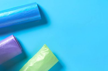 Mavi arka planda tek kullanımlık plastik çöp torbaları. Uzayı kopyala Üst görünüm