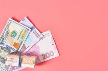 Pembe arka planda farklı banknotlar. Emekli maaşları, maaşlar. Banka kredisi. İş konsepti