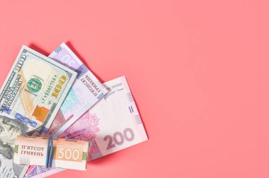 Pembe arka planda farklı banknotlar. Emekli maaşları, maaşlar. Banka kredisi. İş konsepti