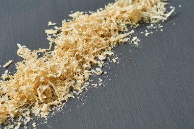 Marangozluk atölyesinde koyu beton yüzeyinde dağınık ahşap talaş sırası