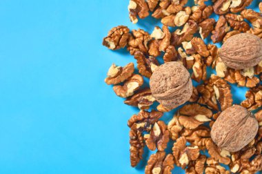 Bir yığın posa ve mavi arka planda ceviz. Uzayı kopyala Üst görünüm