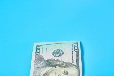 Mavi arka planda 100 dolarlık banknot. Emekli maaşları, maaşlar. Banka kredisi. İş konsepti
