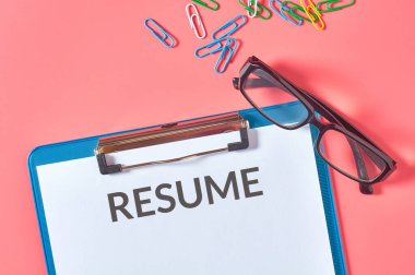 Üzerinde kelimeler olan pano pembe masadaki kırtasiye malzemelerinin yanında devam ediyor. İstihdam kavramı