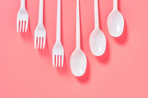 Row White Disposable Spoon Fork Scattered Pink Background Concept Environment — Stock Photo, Image