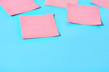 Mavi arka planda bir sürü pembe kare boş kağıt çıkartması vardı. Boşluğu kopyala