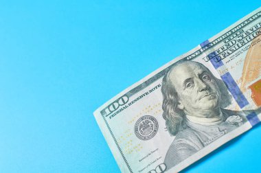 Mavi arka planda 100 dolarlık banknot. Emekli maaşları, maaşlar. Banka kredisi. İş konsepti