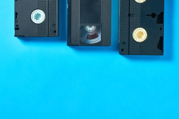Auf Einem Blauen Schreibtisch Liegen Drei Schwarze Alte Vhs Videokassetten — Stockfoto