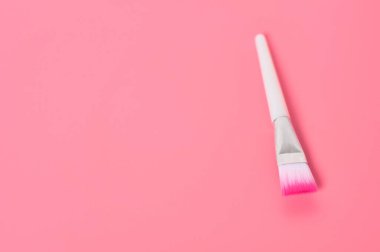 Pembe arka planda bir kozmetik fırça. Güzellik ve cilt bakımı