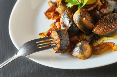 Beton masadaki restoranda, metal çatalın yanında soğanlı ve körili kızarmış muz servis ettim.