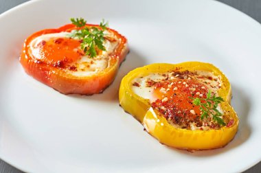 Beton masadaki restoranda kızarmış yumurtayla doldurulmuş dolma biber halkaları servis ettim. Lezzetli kahvaltı.