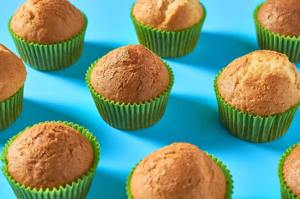 Mnoho Nadýchané Muffiny Zelených Papírových Forem Rozptýlené Modrém Pozadí — Stock fotografie