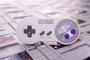 Snes Kartuşları yığınının üstünde bir Süper Nintendo Denetleyicisi