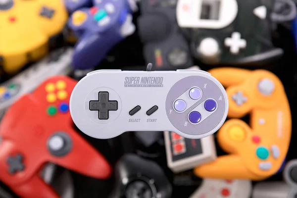 Un Super Nintendo Controller revoloteando sobre un montón de vídeos retro —  Fotos de Stock