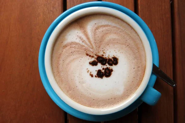 mavi bir fincan sıcak kakao üstten görünüm kahverengi ahşap tablo
