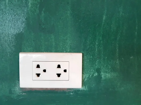 koyu yeşil duvar üzerinde beyaz bir soket