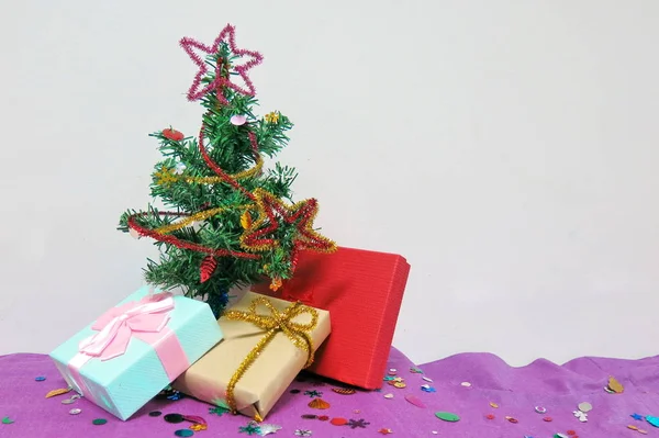 The little Christmas tree and three present boxes preparing for Christmas celebration