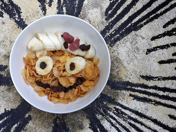 gülen yüz bazı muz, Kuru üzüm ve kuru çilek şeklinde tost altın mısır gevreği bir kâse süslenmiş