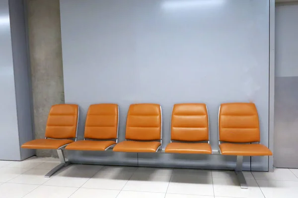 Ряд Пяти Пустых Мест Оранжевого Цвета Аэропорту Стеной Серого Цвета — стоковое фото