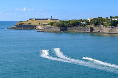 San Juan, Porto Riko - 02 Nisan 2014: Jet ski biniciler bu yönde yaklaşırken tarihi Castillo San Felipe del Morro eski San Juan, nerede bulunduğunu promontory görünümünü.
