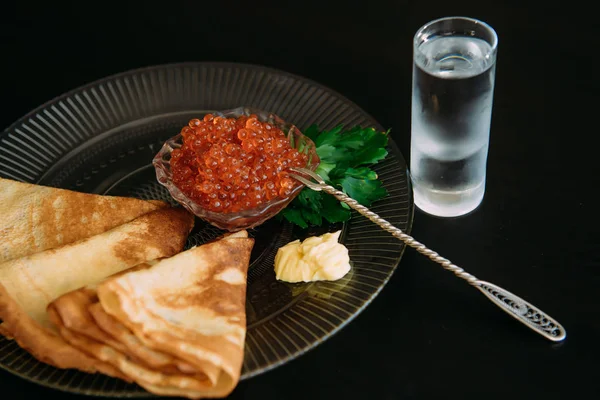 Pancakes with salmon caviar and vodka traditional Russian meal o