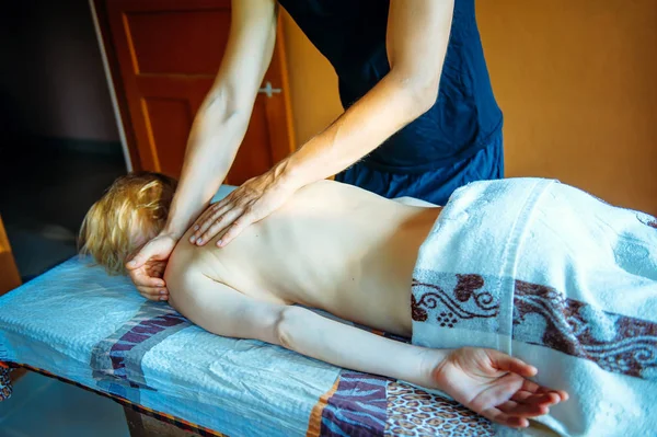 Body care. Spa body massage. Woman having a wellness back massage close up.