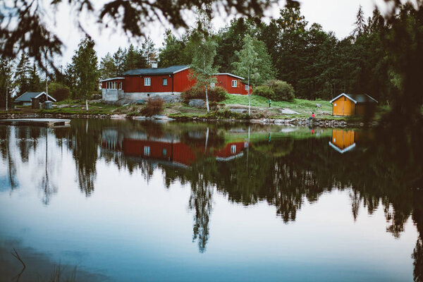 яркие красочные дома у озера рядом с лесом
 