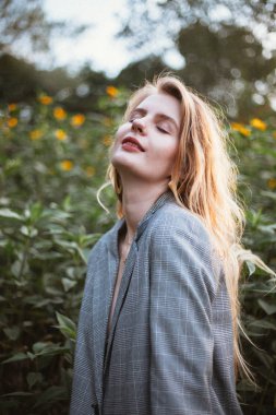 çekici kadın kapalı gözler çayır on güneşli gün istirahat ile gri ceketli 